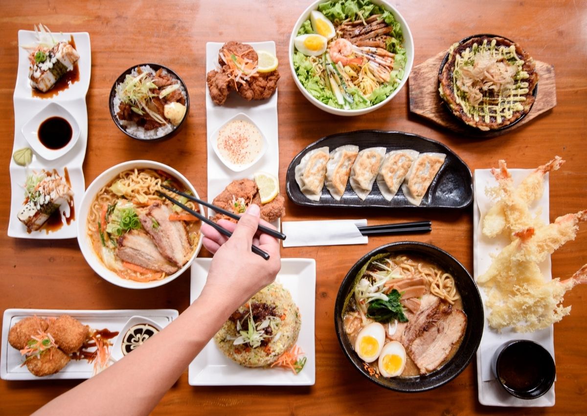 Et bord fylt med japansk mat, alt fra ramen til gyoza og tempurareker.