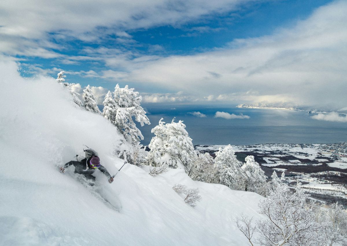 Skikjørere i det snørike landskapet på Hokkaido, Japan