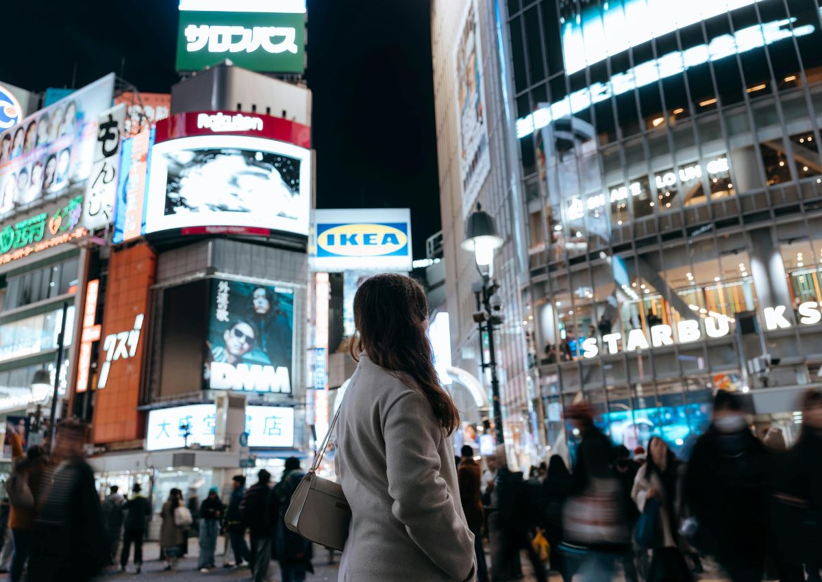 En jente midt i folkelivet ved Shibuya-krysset i Tokyo