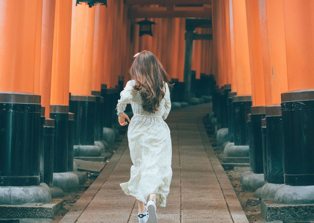 Jente som løper ved Fushimi Inari-helligdommen i Kyoto