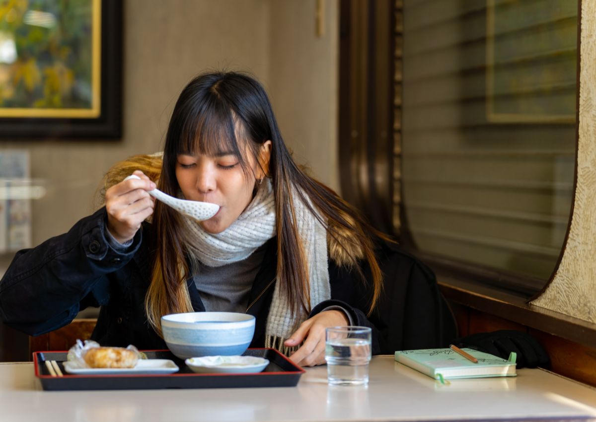 Kvinne som spiser middag på japansk restaurant om vinteren
