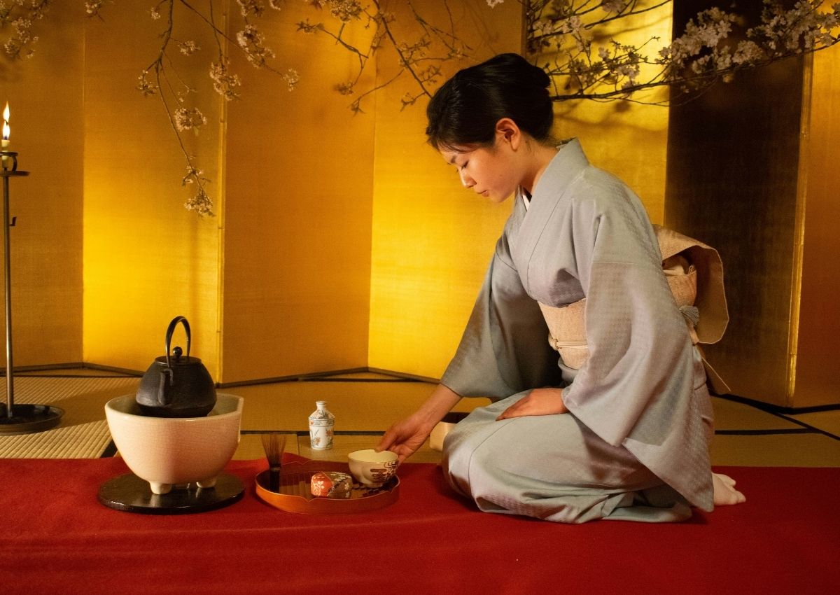 Japansk kvinne i kimono sitter på gulvet under en teseremoni i Kyoto