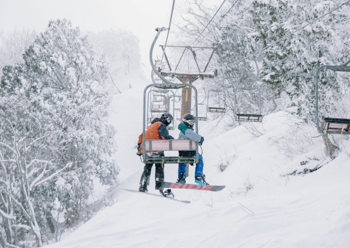 Folk som står på snowboard i Hakuba Ski Resort