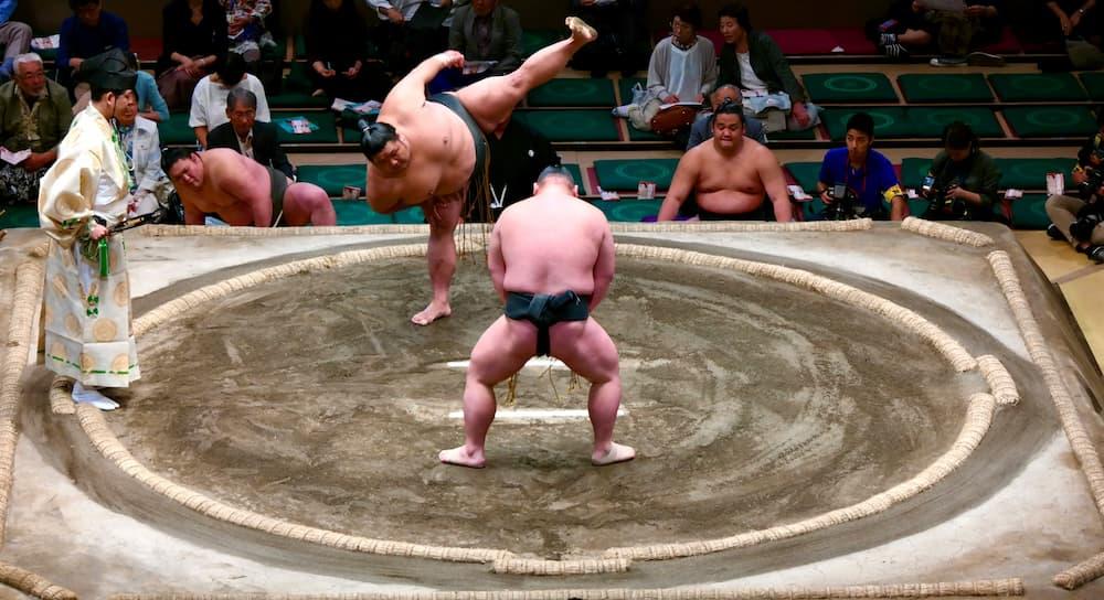 Japanske sumobrytere forbereder seg til kamp i ringen, iført tradisjonell mawashi