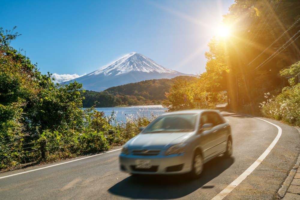 Bilkjøring nær Fuji-fjellet i Japan med bevegelsesuskarphet som viser rask bevegelse på en motorvei ved Kawaguchiko-sjøen
