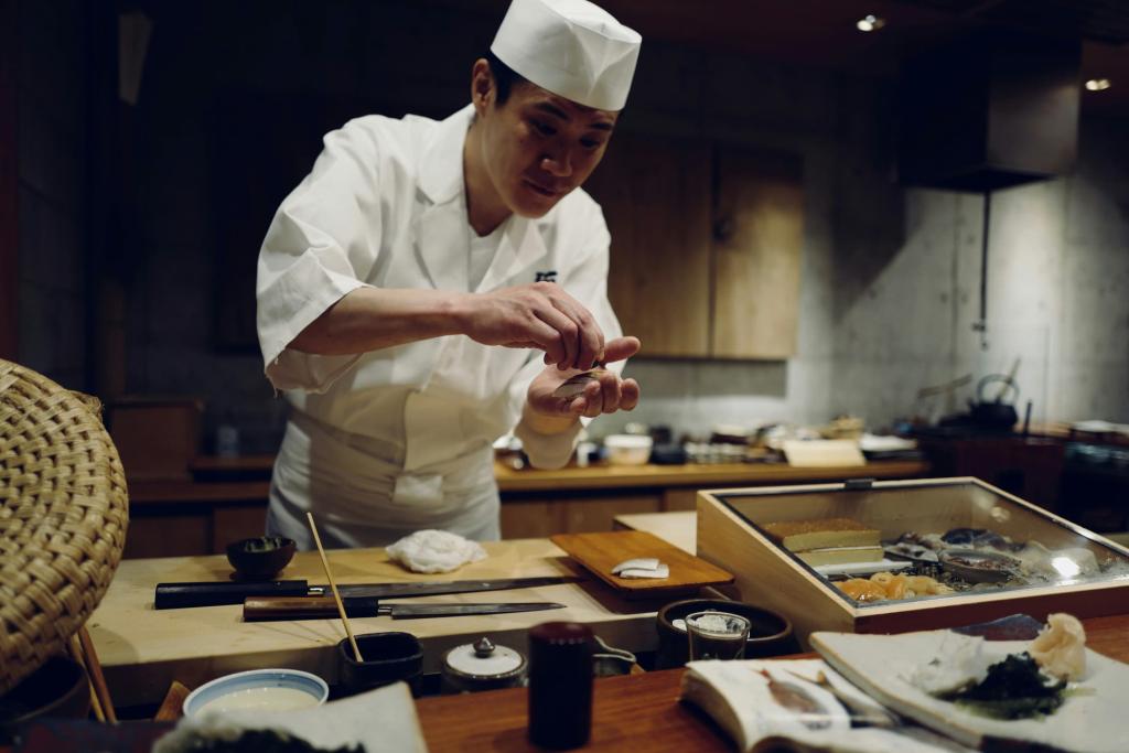 Japansk kokk lager sashimi foran disken på en japansk sushirestaurant