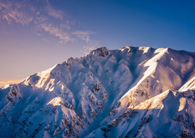 Det snødekte fjellandskapet i Hakuba stråler i det varme lyset fra solnedgangen
