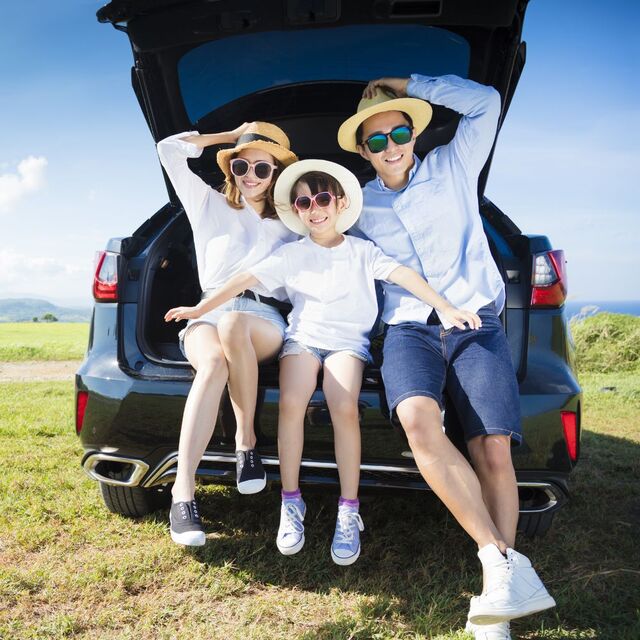 En familie sitter i bilens bagasjerom