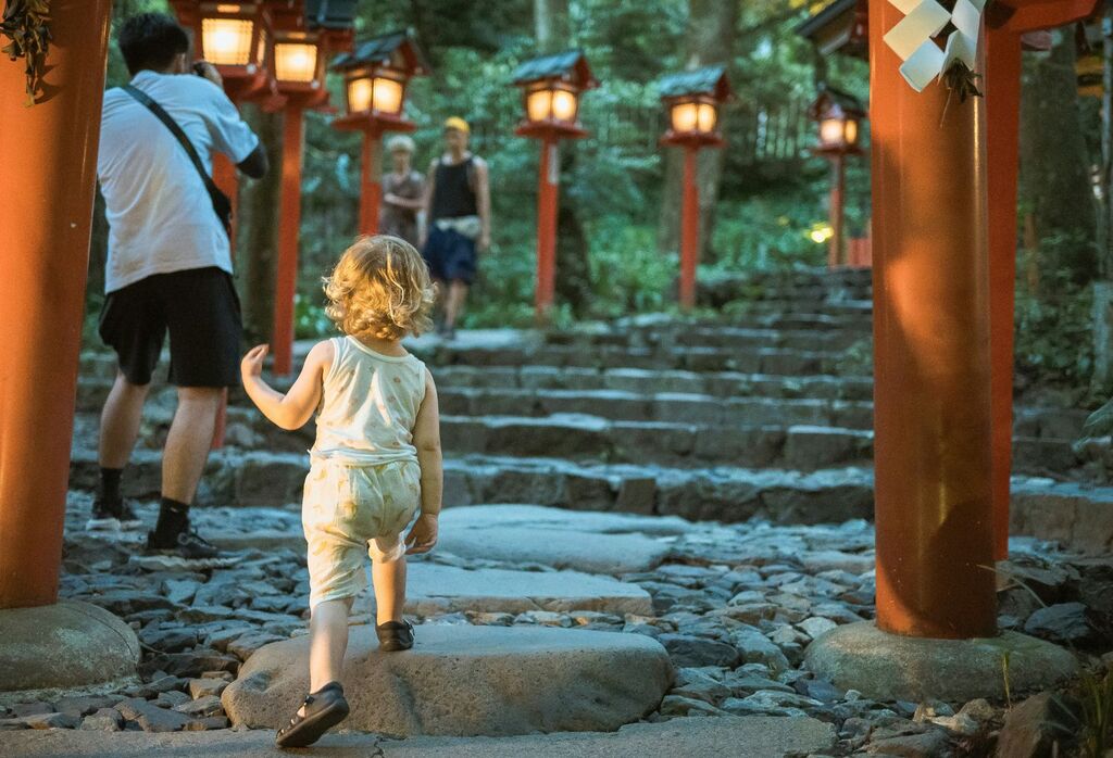 Et lite barn som går opp trapper i Kyoto, Japan